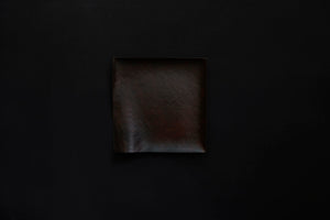 Assiette carrée en papier laquée en noir sur un vermillon