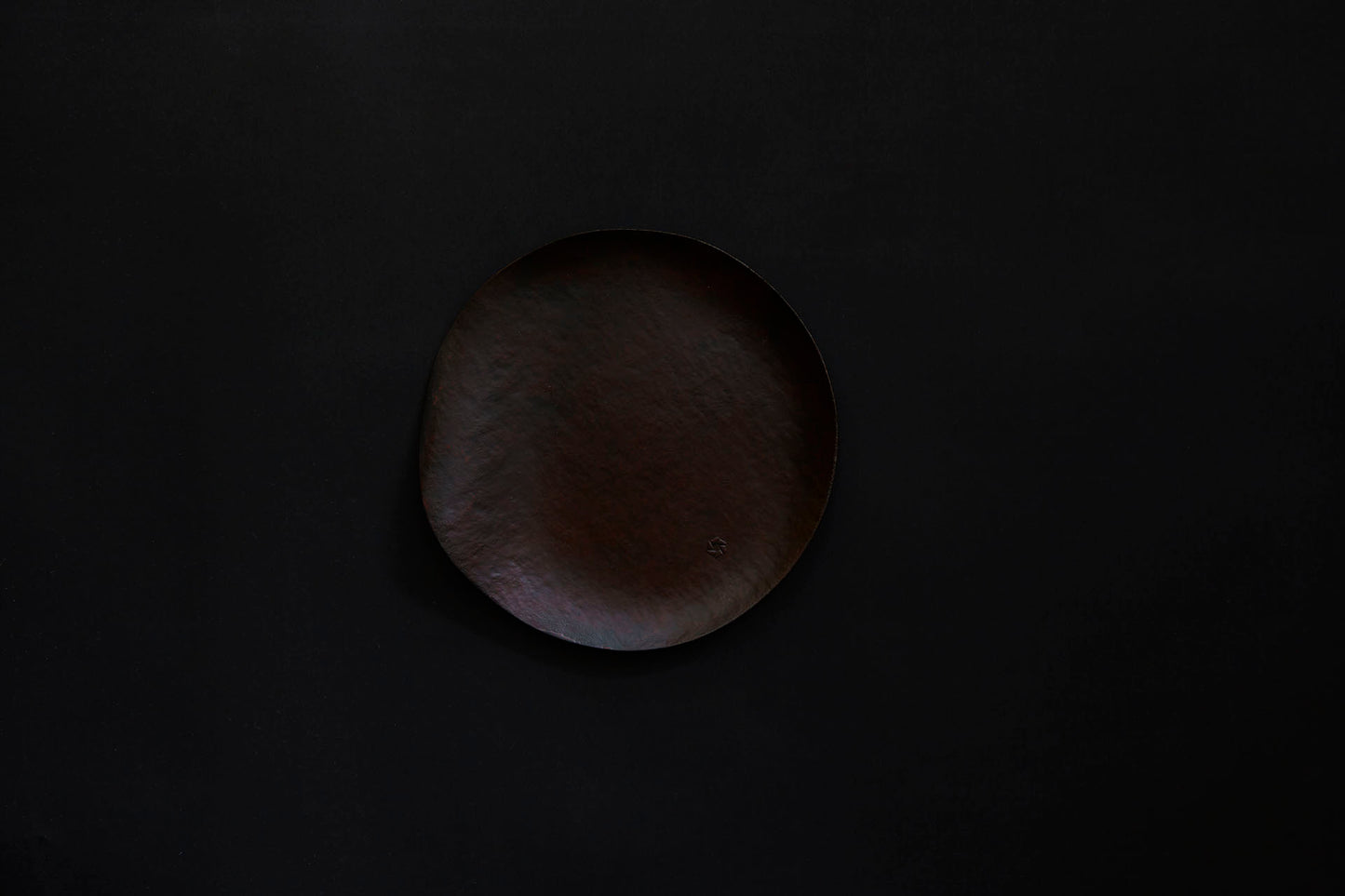 Assiette ronde en papier laquée de couleur ambrée sur un vermillon