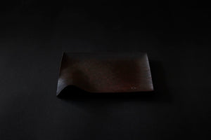 Assiette carrée en papier laquée en noir sur un vermillon