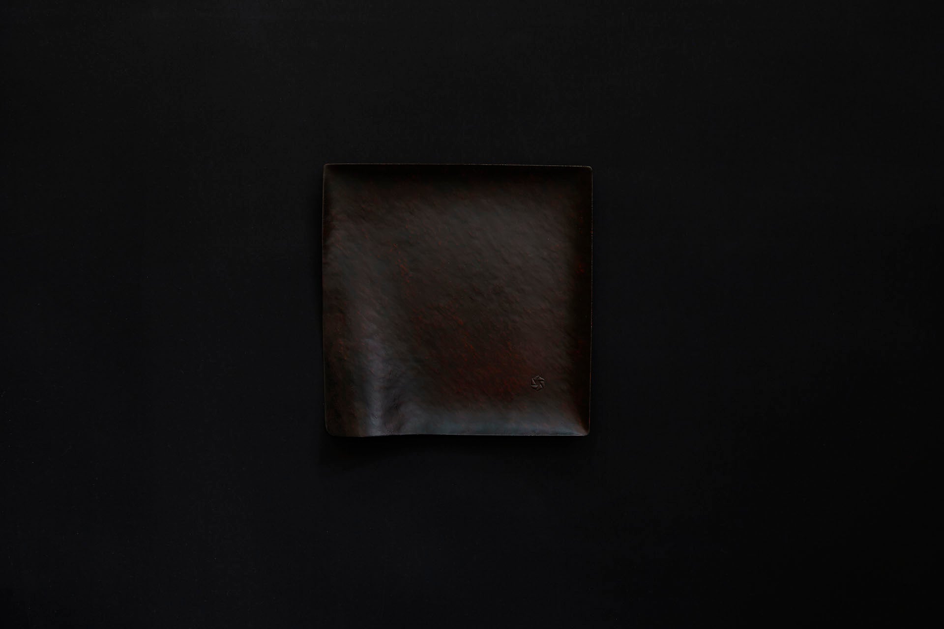 Assiette carrée en papier laquée en noir sur un vermillon