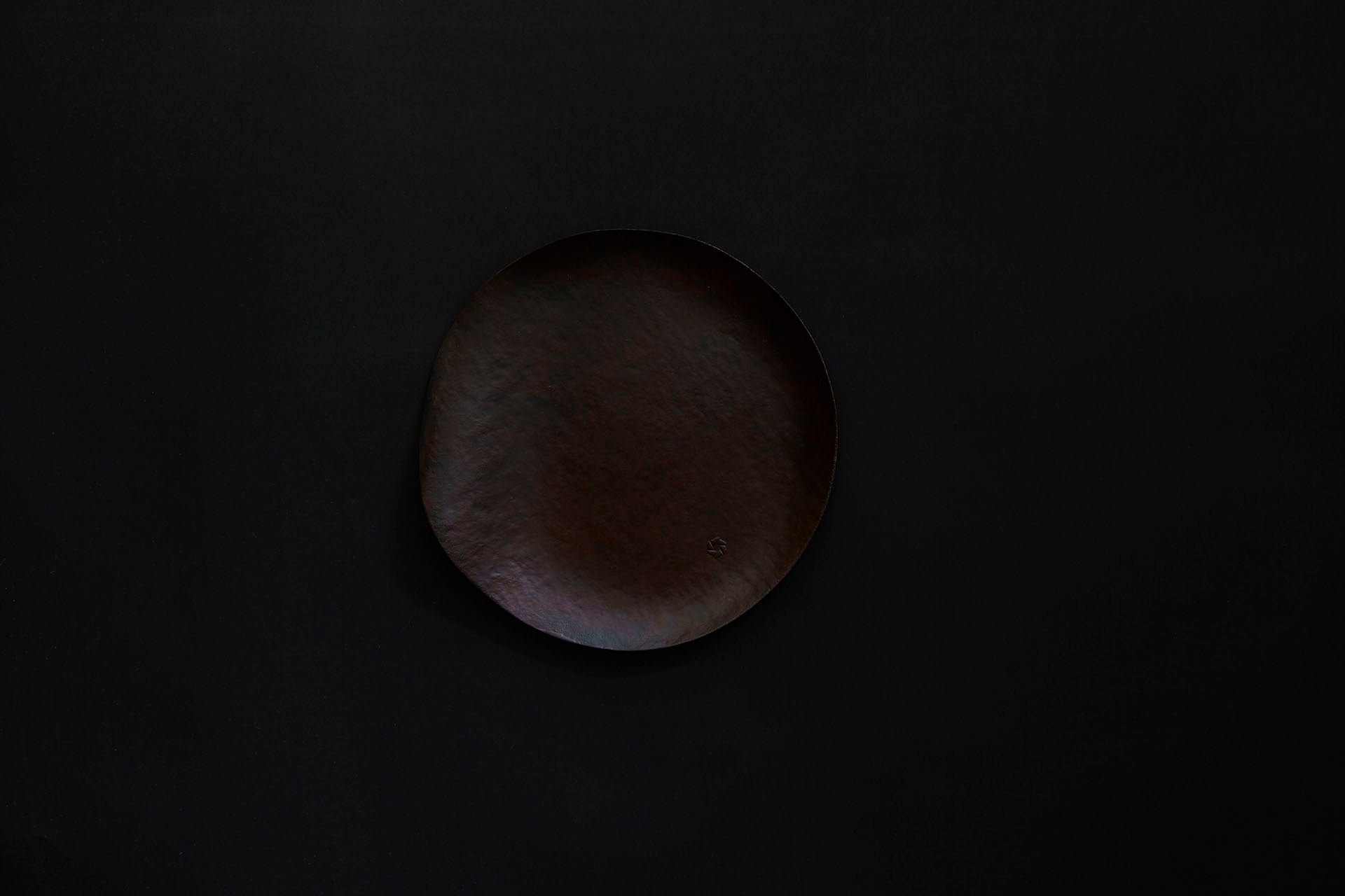 Assiette ronde en papier laquée de couleur ambrée sur un vermillon