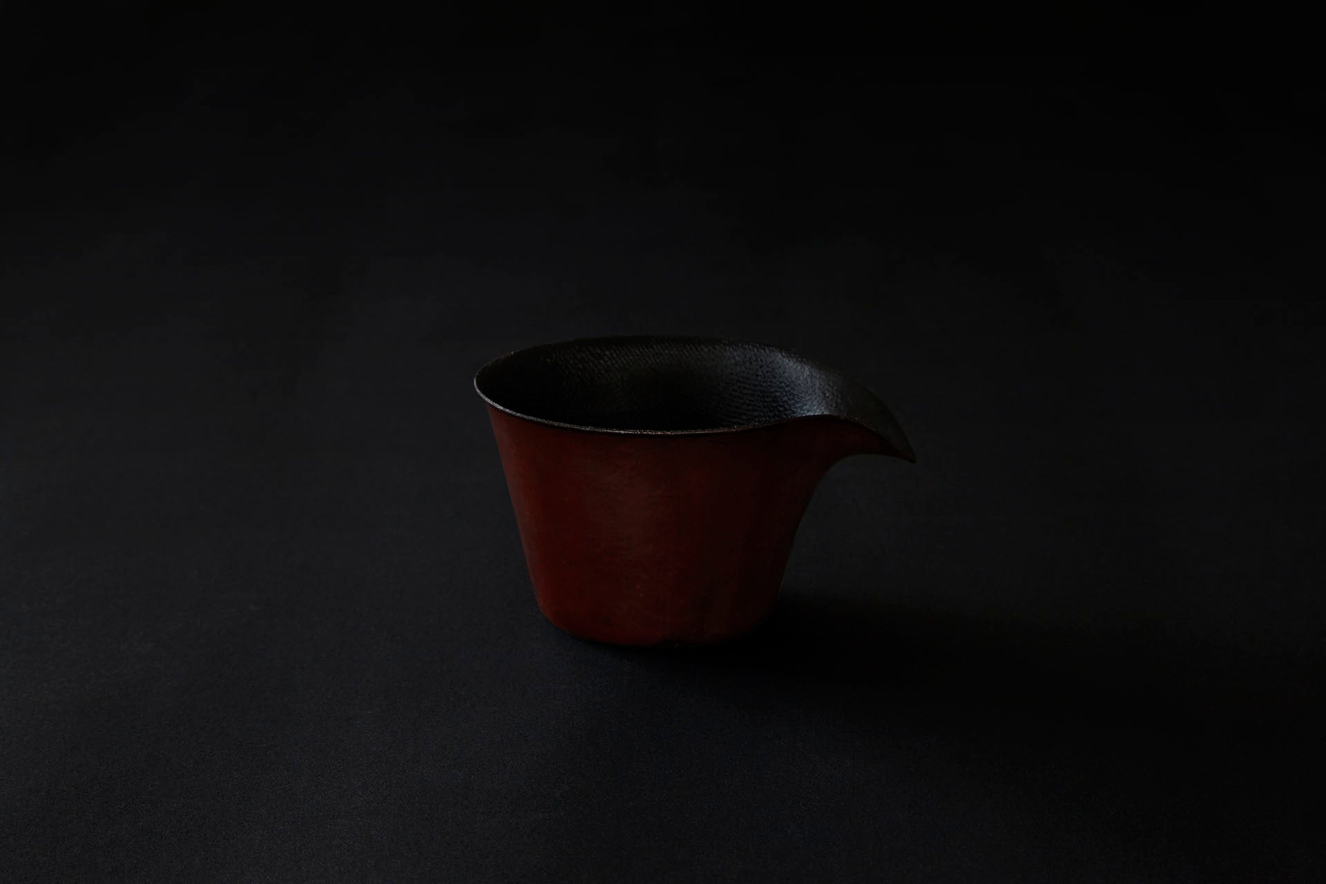 Tasse à café en papier laquée en couleur ambrée sur un vermillon