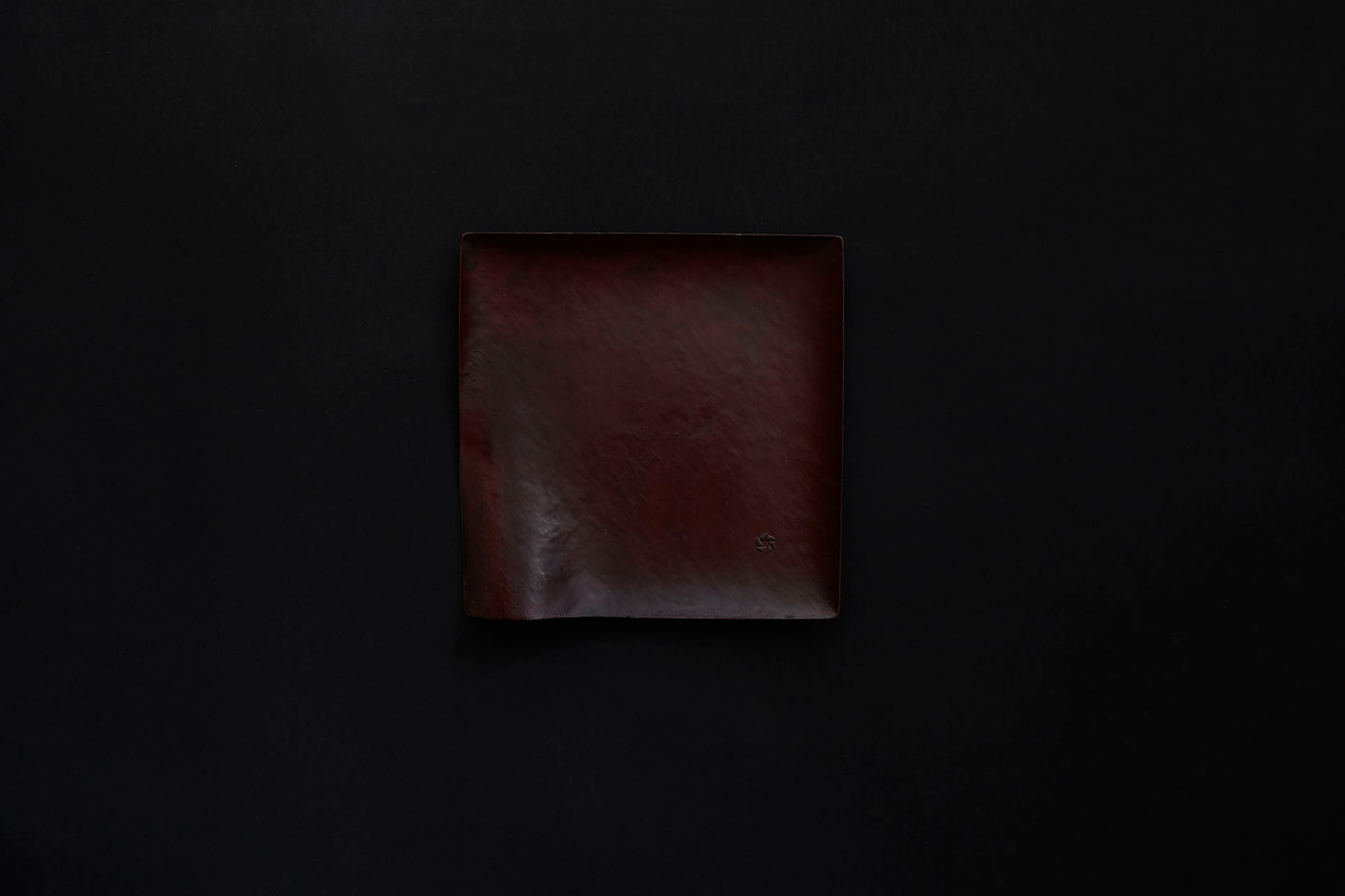 Assiette carrée en papier laquée de couleur ambrée sur un vermillon