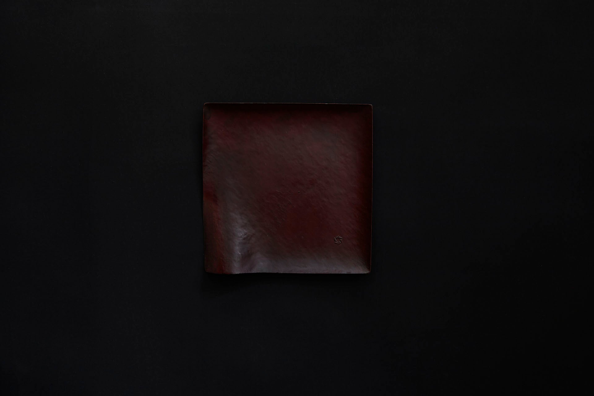 Assiette carrée en papier laquée de couleur ambrée sur un vermillon