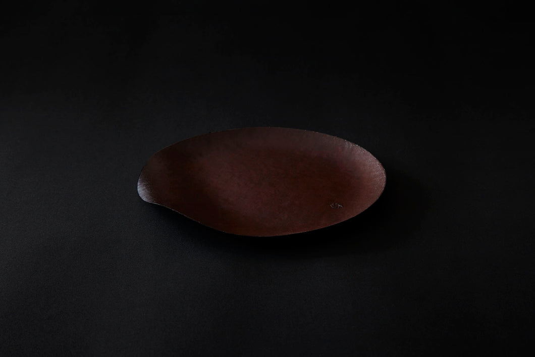 Assiette ronde en papier laquée en noir sur un vermillon