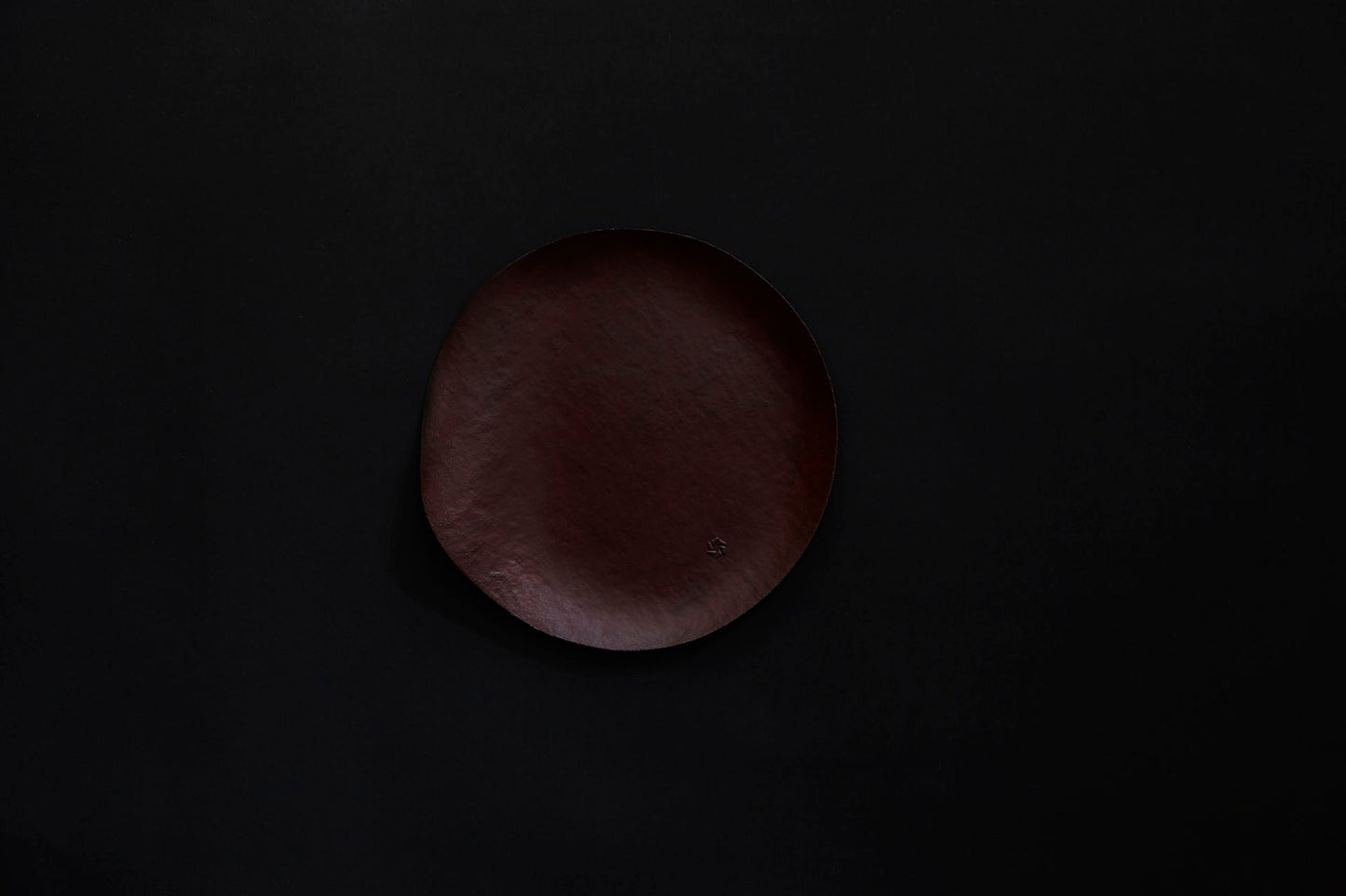 Assiette ronde en papier laquée en noir sur un vermillon