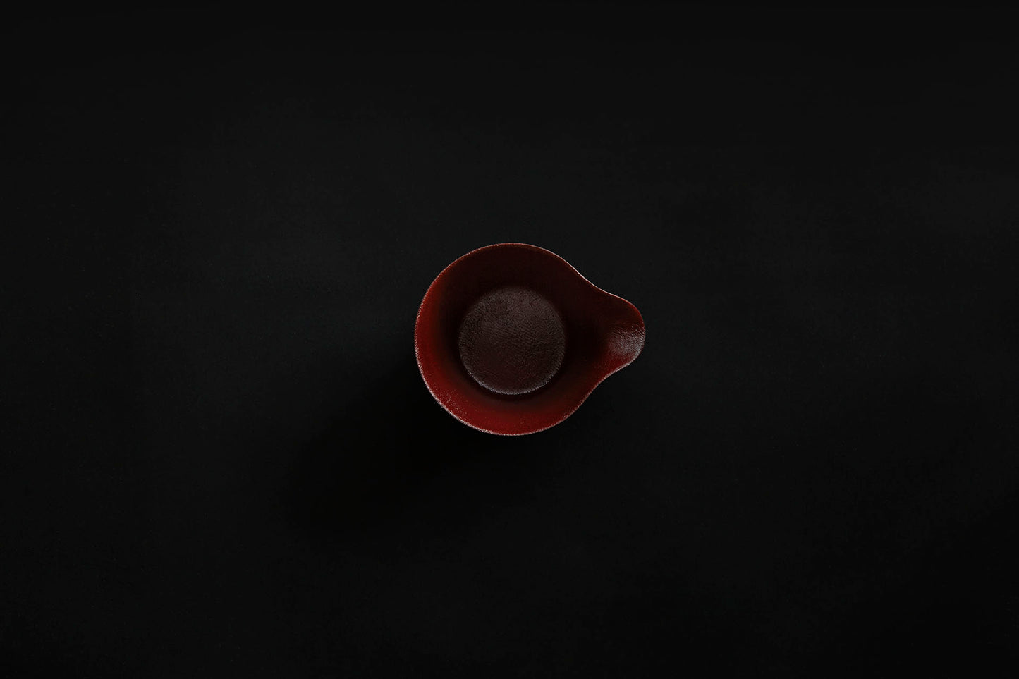 Tasse à café en papier laquée en noir sur un vermillon