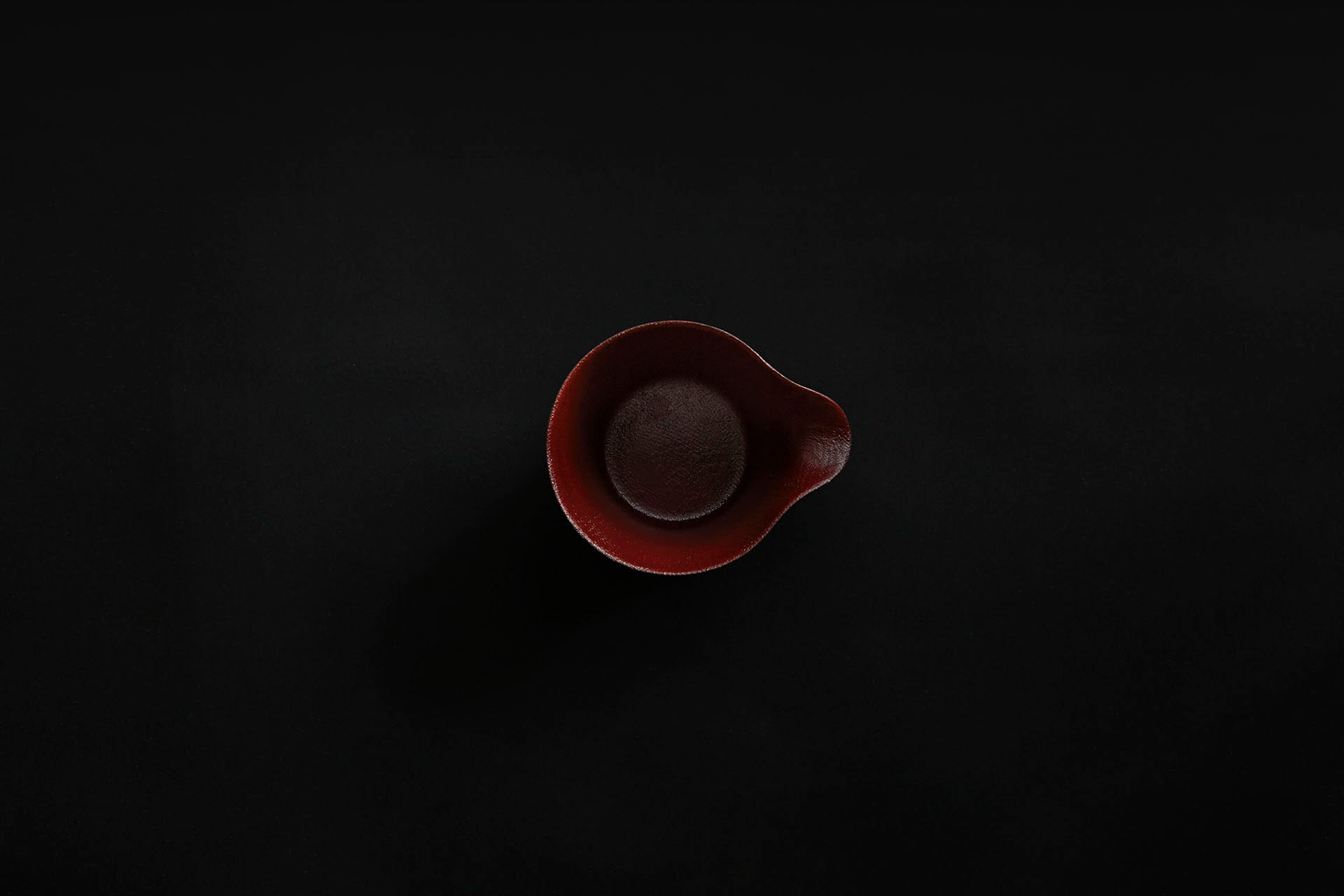 Tasse à café en papier laquée en noir sur un vermillon